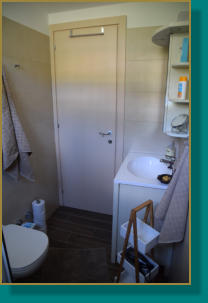 gefliestes Badezimmer mit Waschtisch, Dusche, WC, Föhn vorhanden